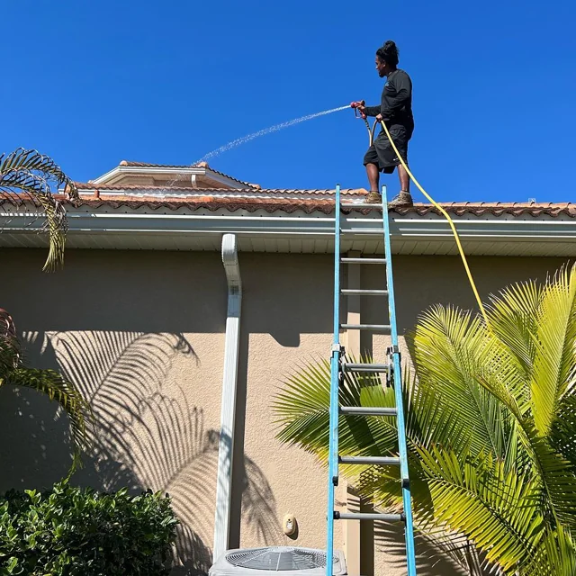 JBC technician soft washing a roof in Orlando FL